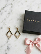 Aria geometric sparkle drop earrings in a TUVELLE box on a gold-toned fabric background