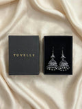 Close-up of antique silver-tone jhumka earrings with patterned domes and dangling bead fringe
