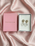Close-up of sparkling floral-inspired earrings with clear faceted teardrop pendants
