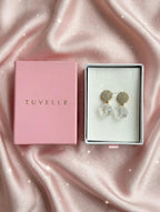 Close-up of sparkling floral-inspired earrings with clear faceted teardrop pendants