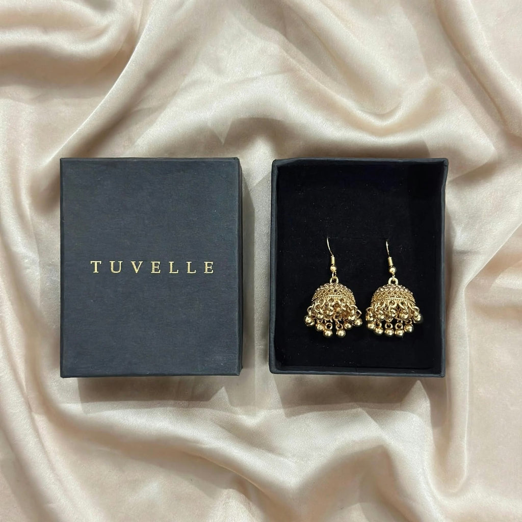 Close-up angled view of textured gold-tone jhumka domes and bead fringe