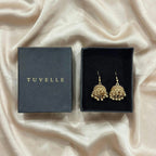 Close-up angled view of textured gold-tone jhumka domes and bead fringe