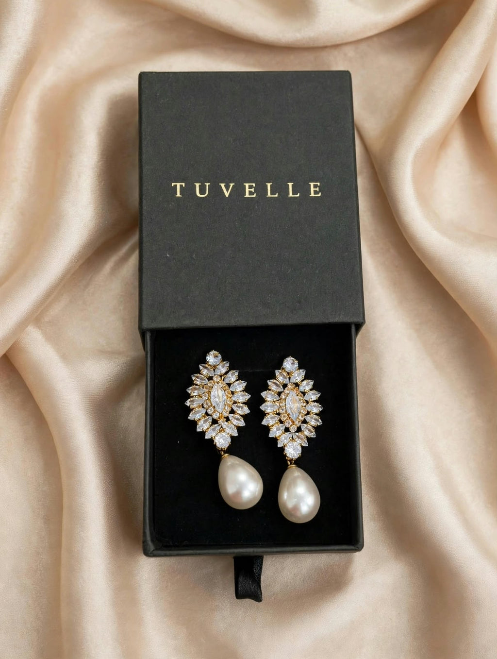 Top view of floral pearl-look drop earrings in a black TUVELLE box