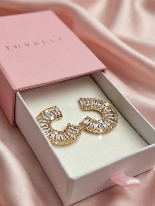 Gold-tone sparkling C-hoop earrings in a pink TUVELLE box on pink satin